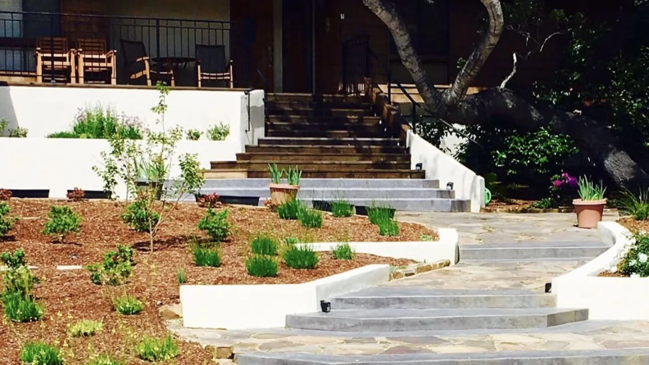 Concrete steps and flagstone landings between stucco planter walls by Aguilar and Sons Construction