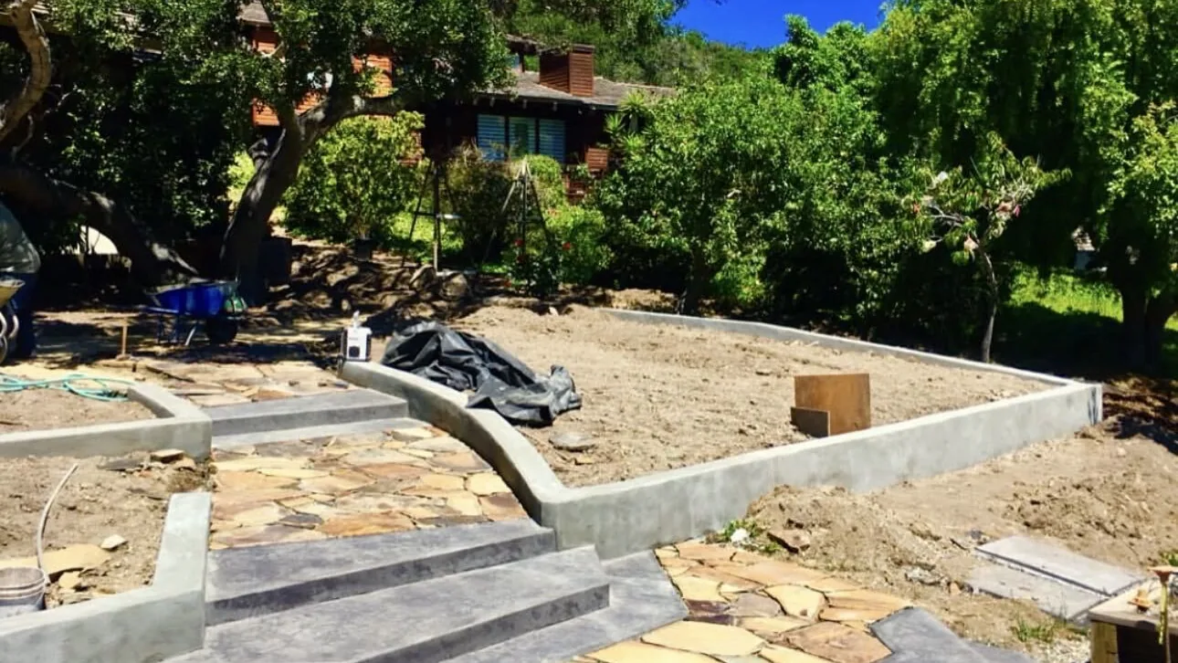 Ranch house with an oak above a flagstone walk and new concrete curbs