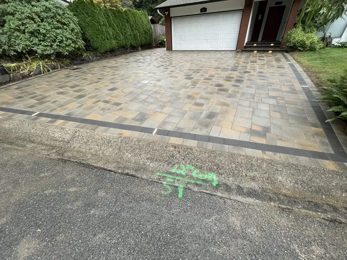 Finished paver driveway with a dark border band where it meets the street