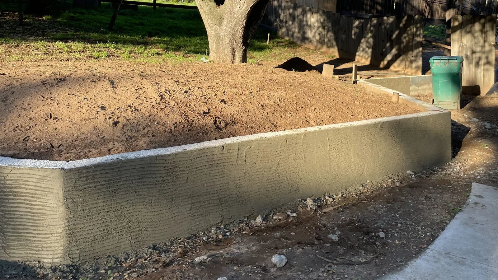 Curved retaining wall and new concrete walkway by Aguilar and Sons Construction